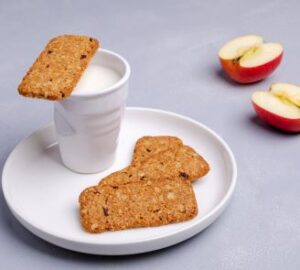 Oatmeal bars on plate with milk and sliced apple