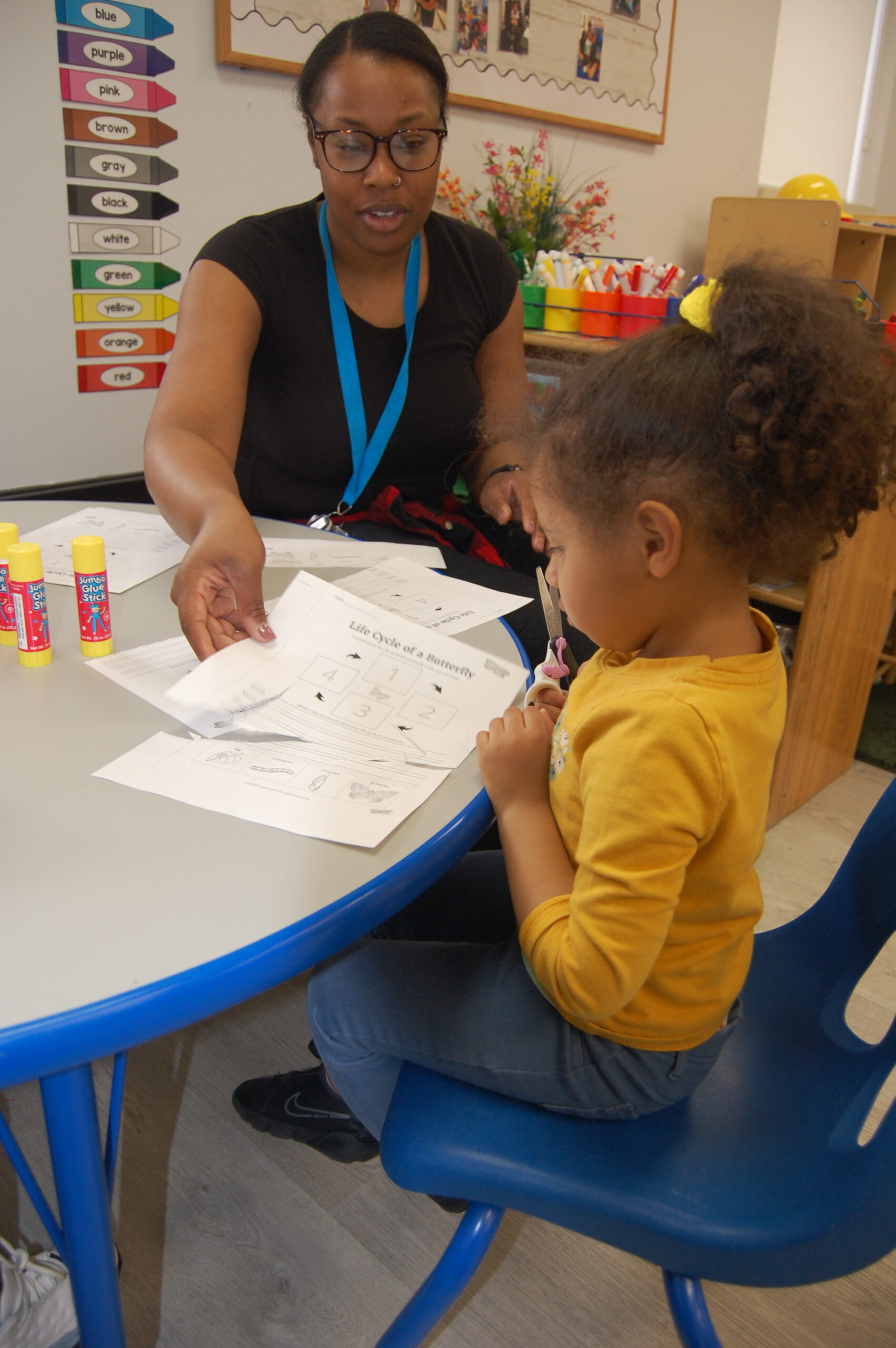 Preschool teacher working with student at table