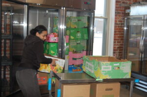 Young woman stacking boxes near a refrigerator