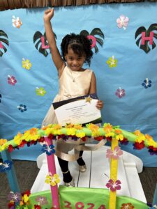 Black girl with arm raised in triumph on decorated bridge