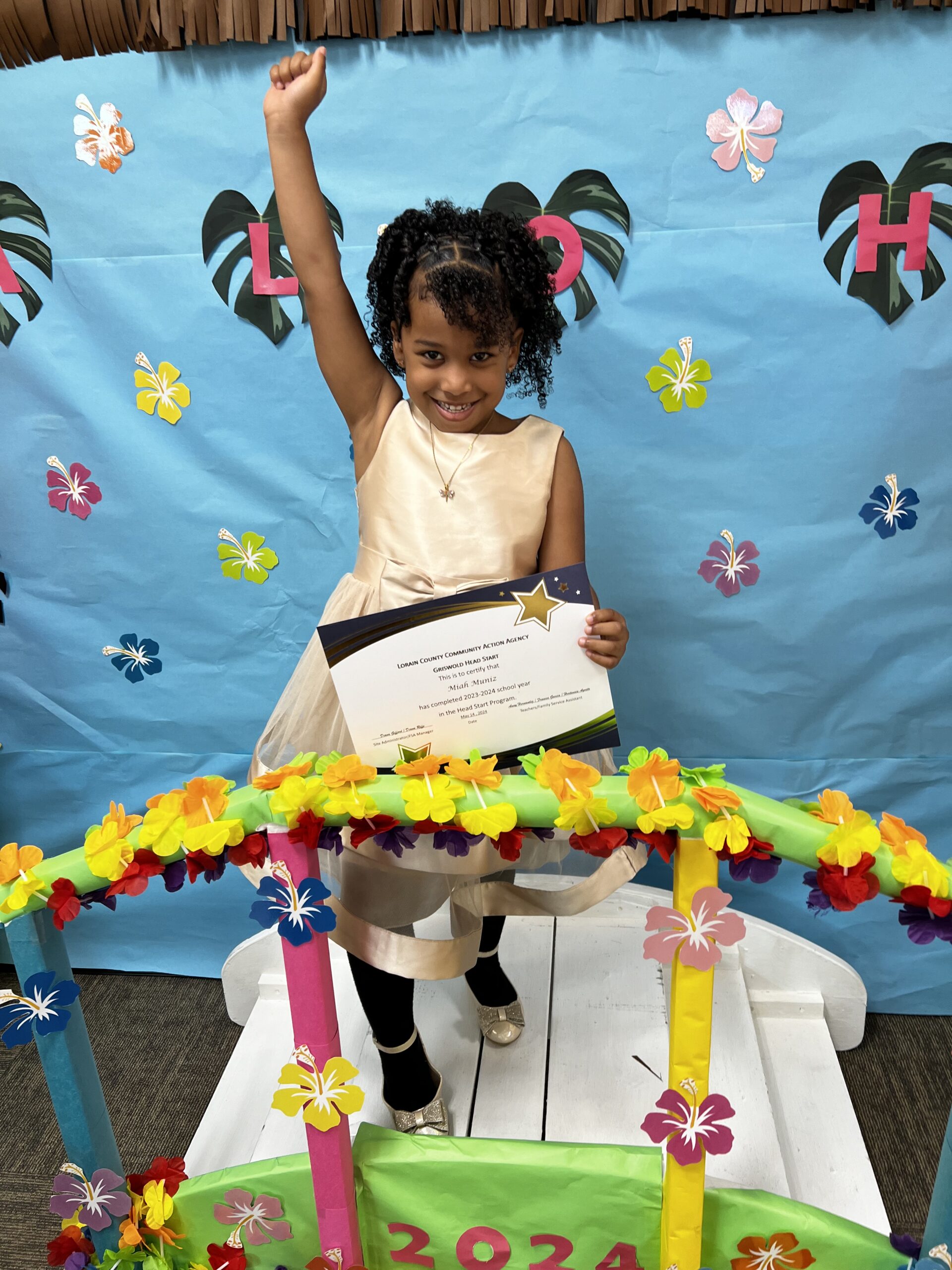 Black girl with arm raised in triumph on decorated bridge