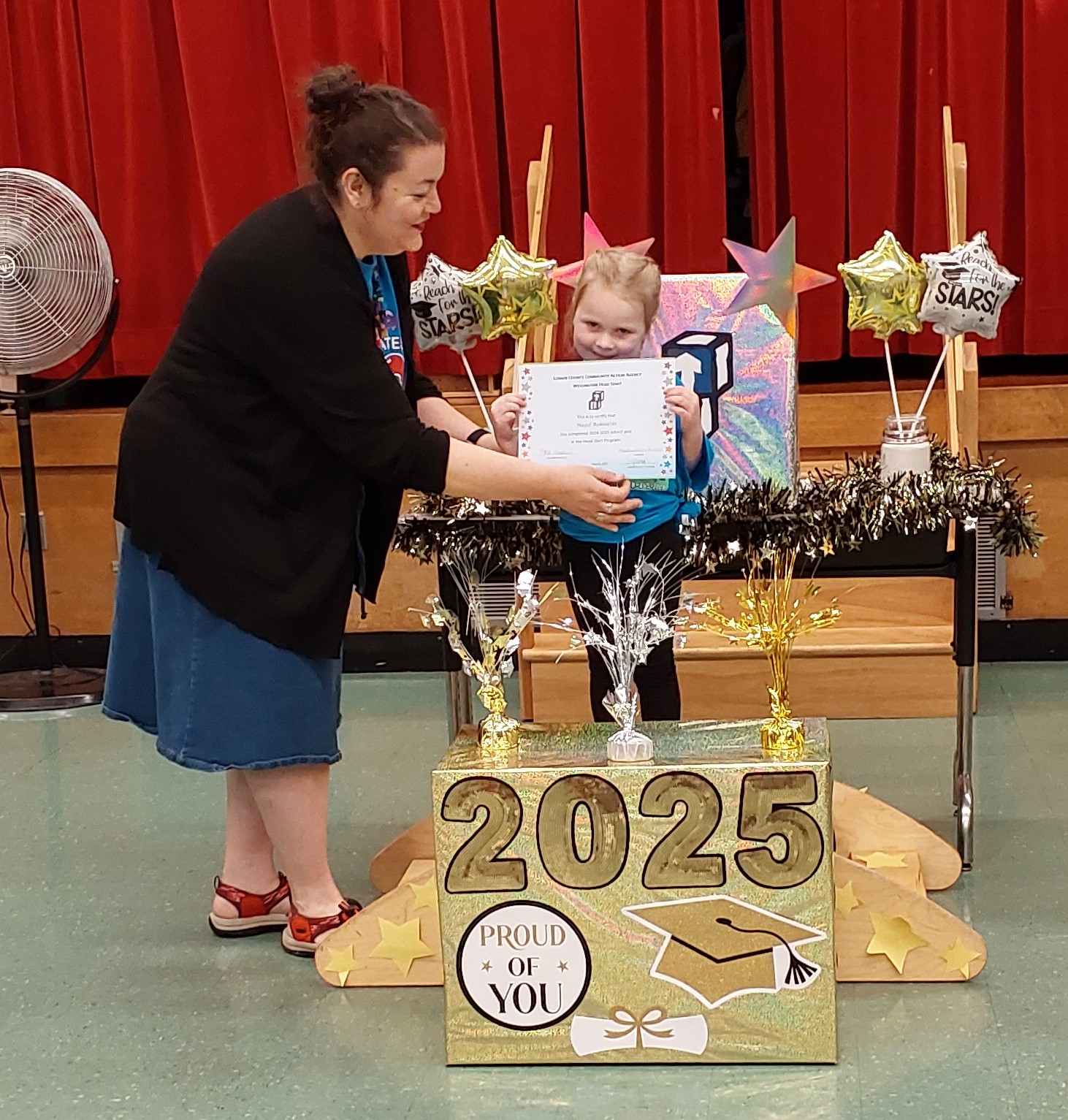 Teacher presenting preschooler with certificate